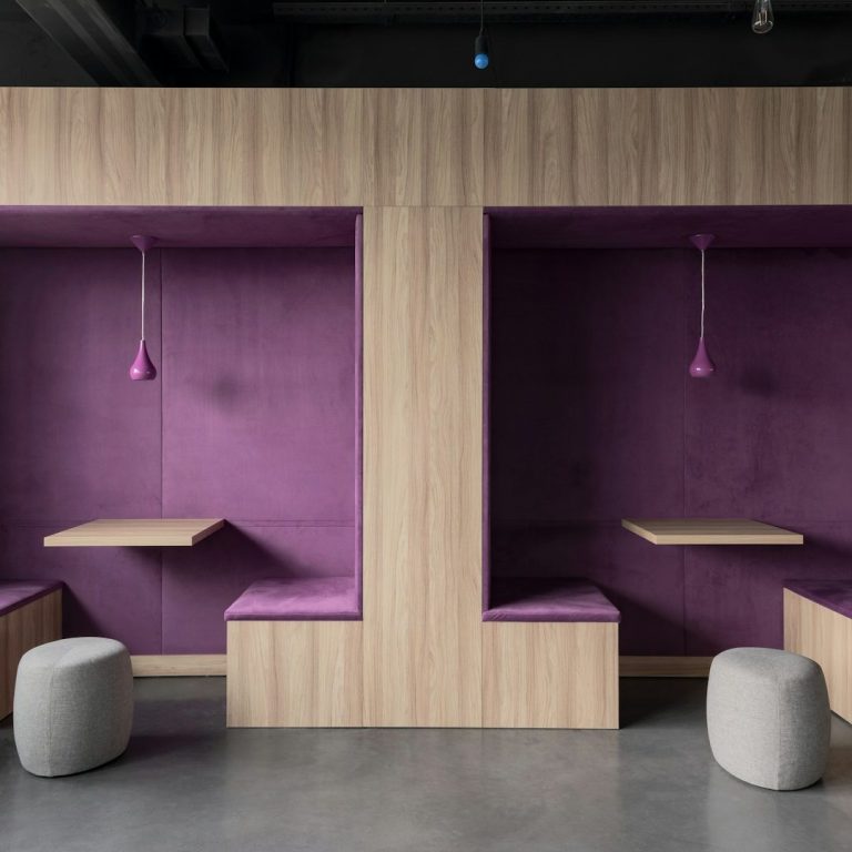 Modern interior with two purple seating nooks and wooden accents.